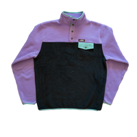 Produzida a três cores em malha polar com aplicação de bolso no peito e viés em algodão. O cinza concreto, a lilás lavanda e o verde elétrico como exagero da natureza que “rasga” o alcatrão, são o novo “cool statement” desta temporada.