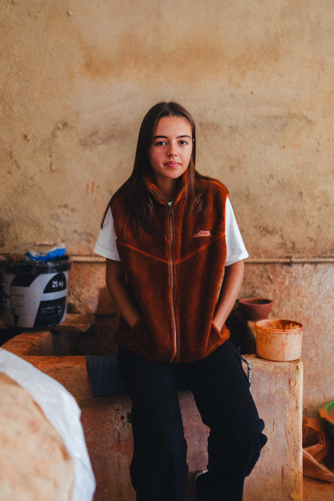 Malha Sherpa em castanho alaranjado, cor do barro que resulta das condições geológicas e das amplitudes térmicas que se fazem sentir no alto Alentejo, com forro polar em cinza no interior que te dá o aconchego que precisas. Bolsos laterais com zipper e logo bordado na frente e no escapulário.