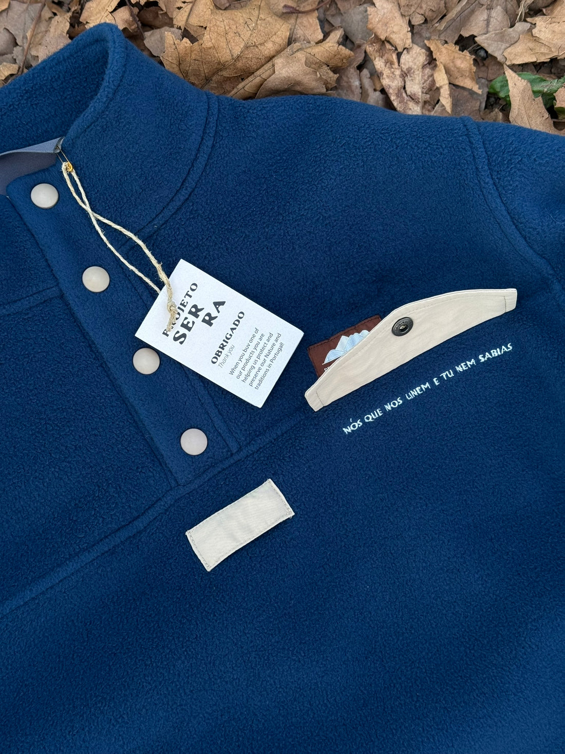 Produzida em malha polar azul marinho 100% Polyester reciclado com aplique no peito onde podes colocar/prender aquilo que o teu coração pede.  