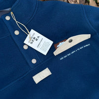 Produzida em malha polar azul marinho 100% Polyester reciclado com aplique no peito onde podes colocar/prender aquilo que o teu coração pede. 