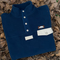 Produzida em malha polar azul marinho 100% Polyester reciclado com aplique no peito onde podes colocar/prender aquilo que o teu coração pede. 