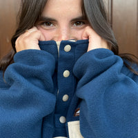 Produzida em malha polar azul marinho 100% Polyester reciclado com aplique no peito onde podes colocar/prender aquilo que o teu coração pede.  