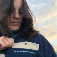 Produzida em malha polar azul marinho 100% Polyester reciclado com aplique no peito onde podes colocar/prender aquilo que o teu coração pede.  