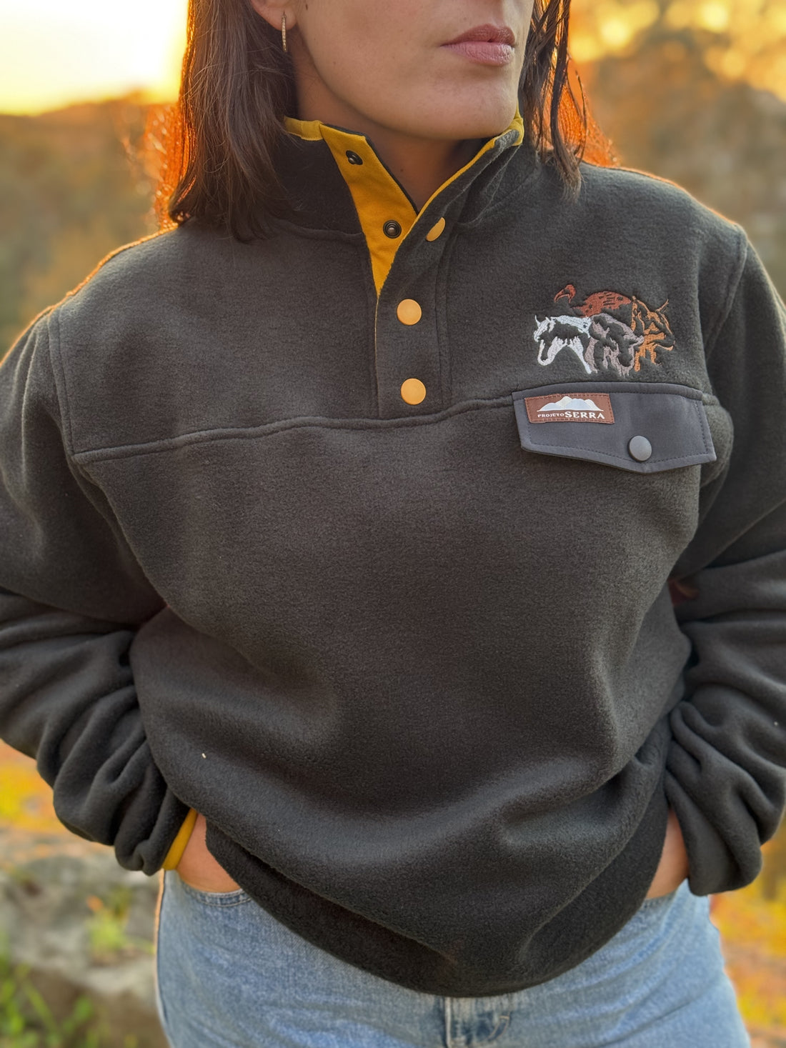 Produzida em malha polar cinza escuro 100% Polyester reciclado com bordado no peito que homenageia as espécies da região. São elas o Grifo, o Lince Ibérico, o Bisonte Europeu e o Cavalo Sorraia. 